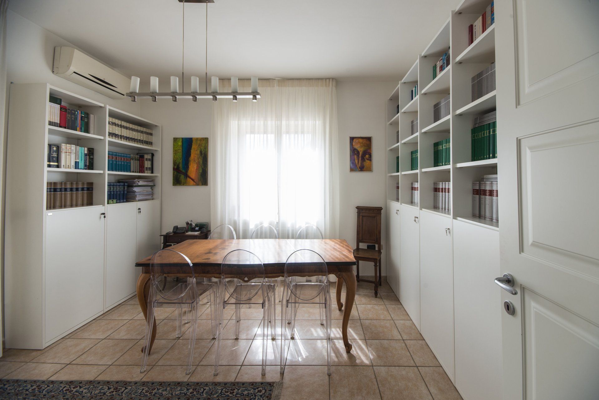 Una sala da pranzo con tavolo, sedie e scaffali pieni di libri.