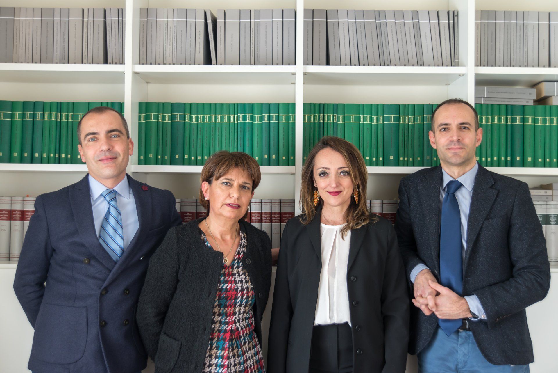 Un gruppo di persone posa per una foto davanti a una libreria.