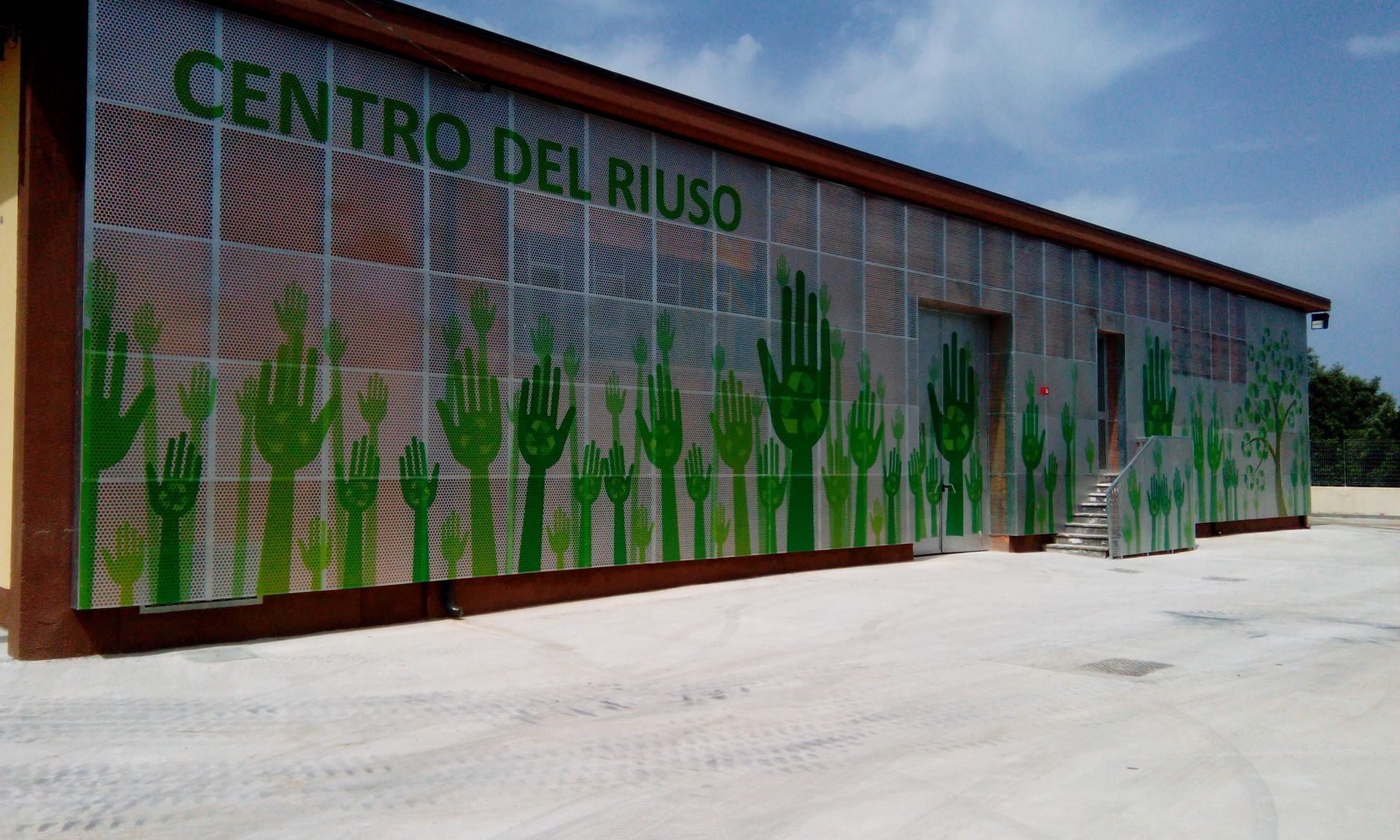 Un edificio con un murale raffigurante delle mani su un lato.