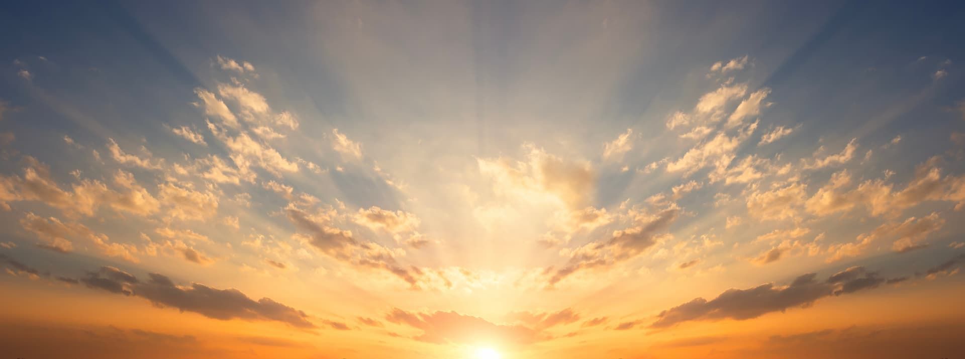 Sunset sky with glowing orange clouds over a calm horizon