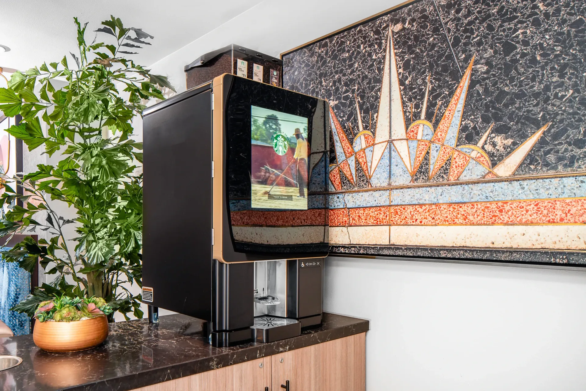 Starbucks coffee machine in a community lounge with modern art.