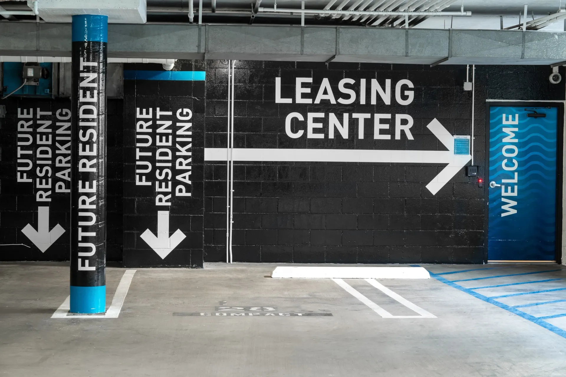 Leasing center entrance with directional signage for future resident parking at The Preston in Los Angeles, CA.