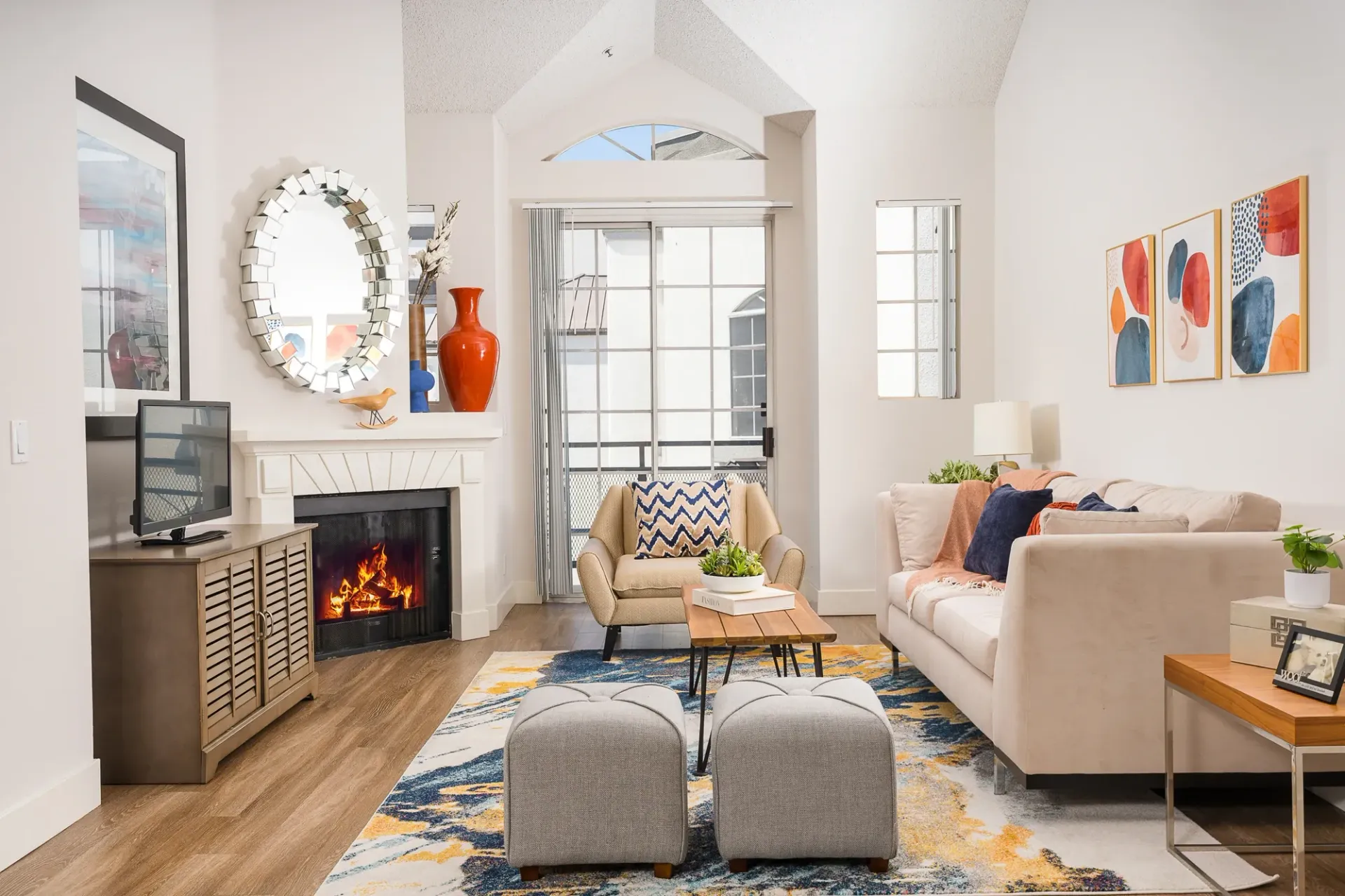 Cozy living room with fireplace, sofa, armchair, and ottoman at The Preston in Los Angeles, CA.
