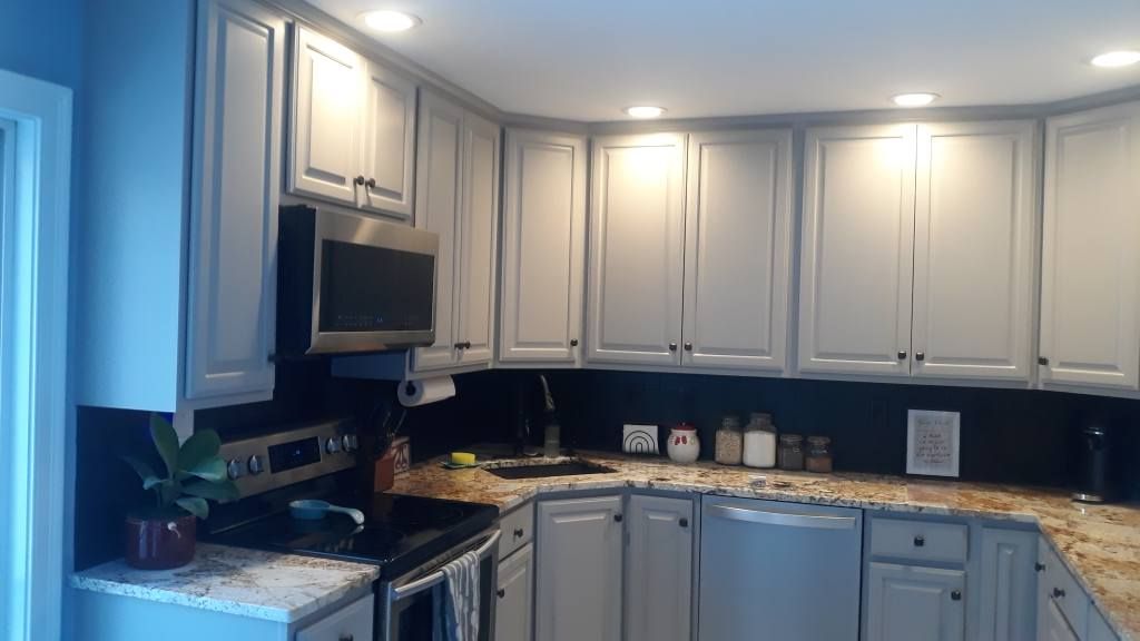 Kitchen with gray cabinets, granite countertops, and a black backsplash.
