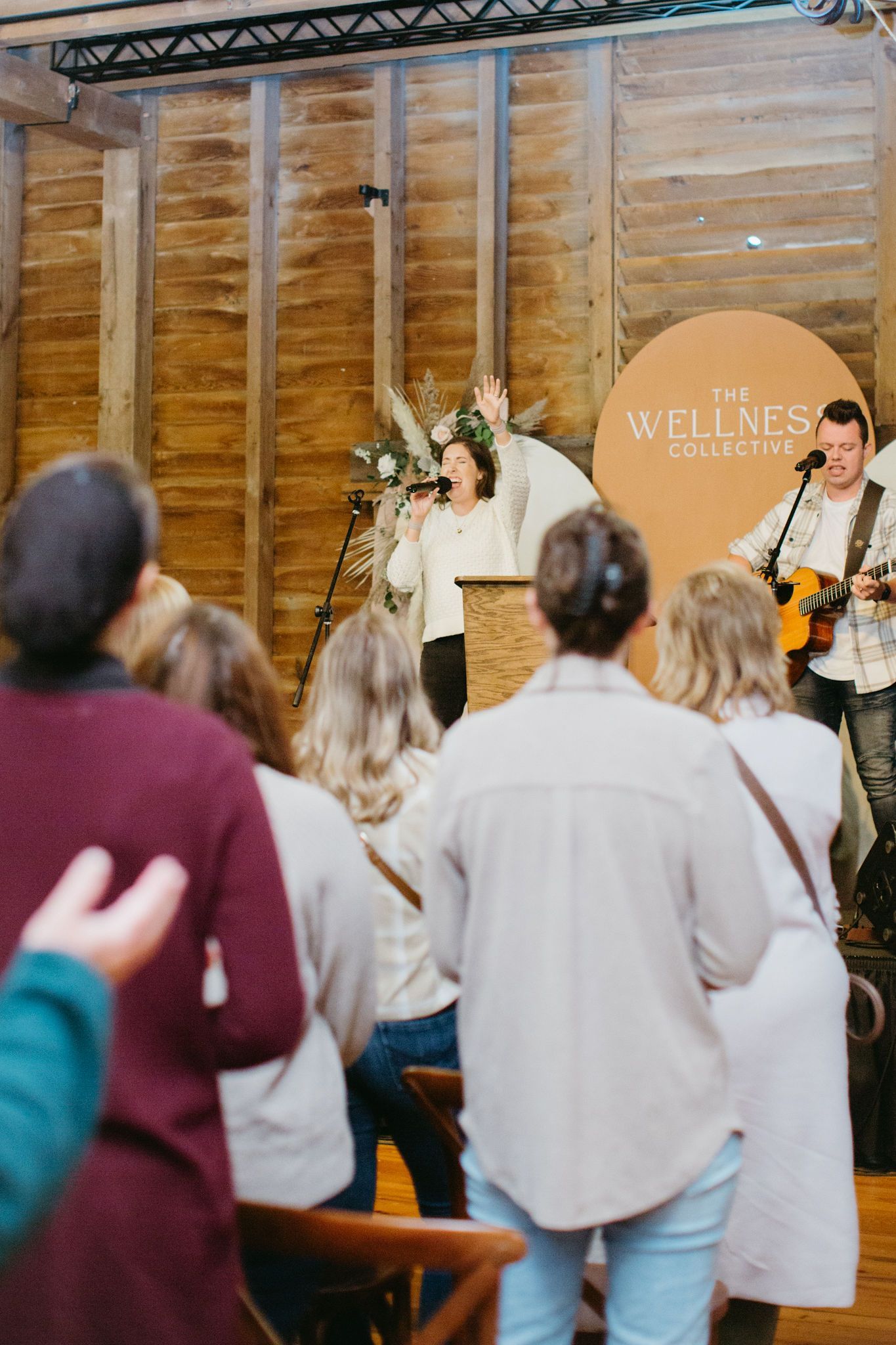 A man is playing a guitar and singing into a microphone while a woman sings into a microphone.