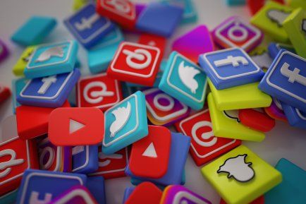Una pila de coloridos íconos de redes sociales sobre una mesa.