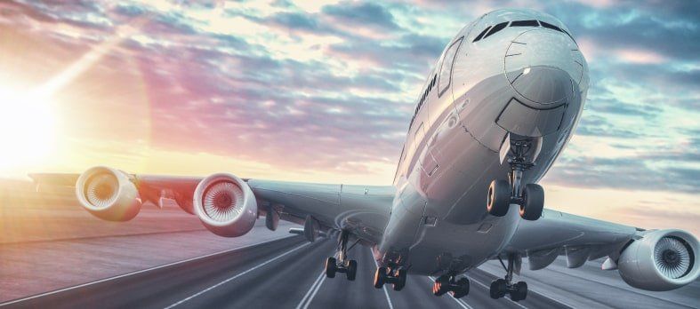 Un avión está despegando de una pista del aeropuerto al atardecer.