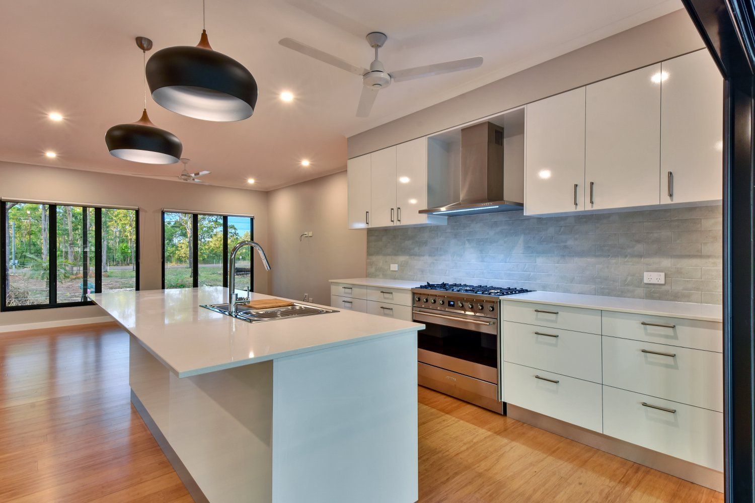 A Kitchen With White Cabinets , Stainless Steel Appliances , A Large Island — SLS Builders Pty Ltd in Humpty Doo, NT