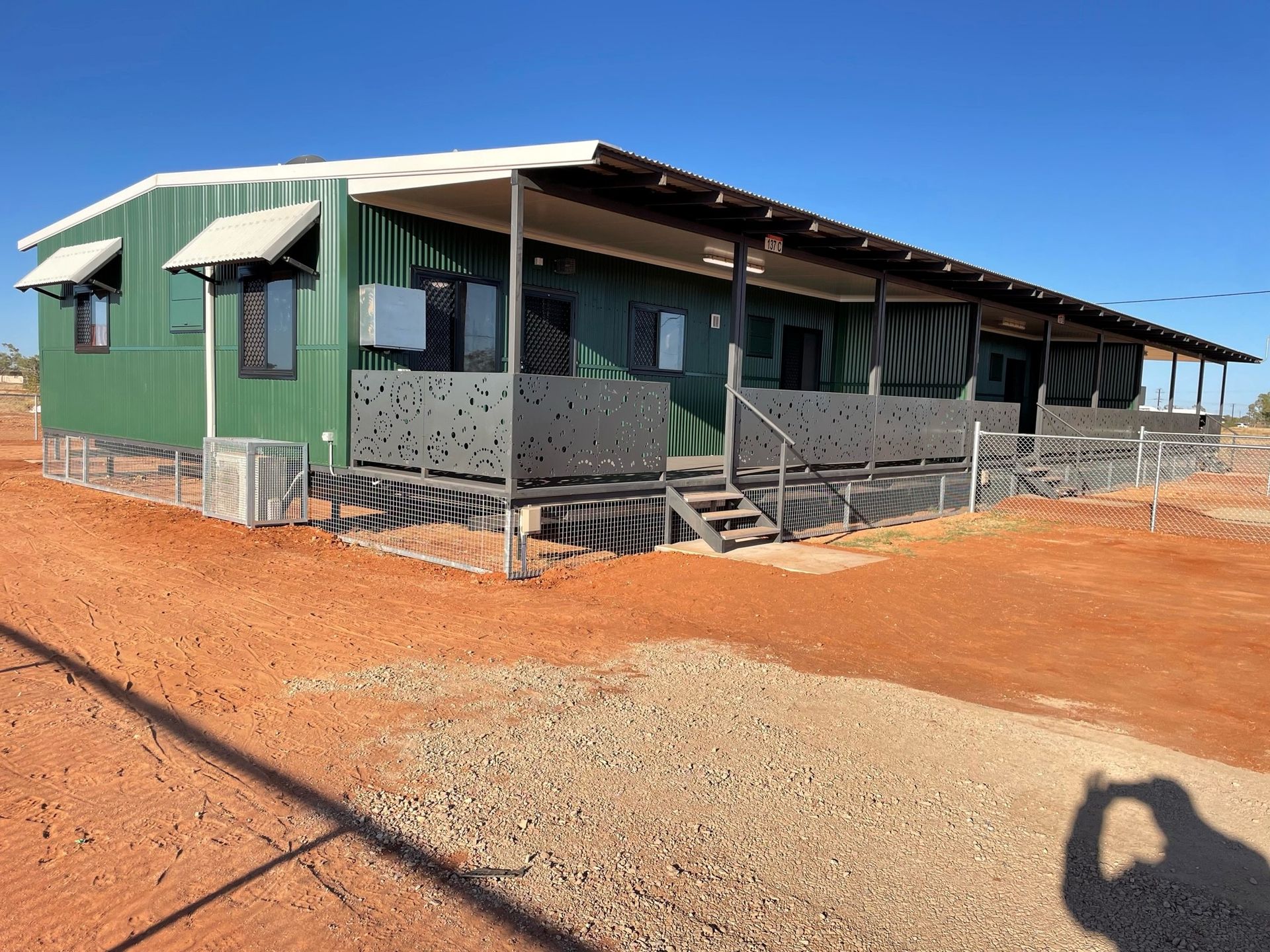 green building with railings and red dirt around it — SLS Builders Pty Ltd in Humpty Doo, NT