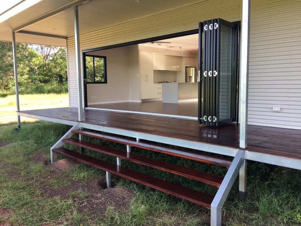 A House With A Wooden Deck And Stairs Leading To It — SLS Builders Pty Ltd in Kununurra, WA