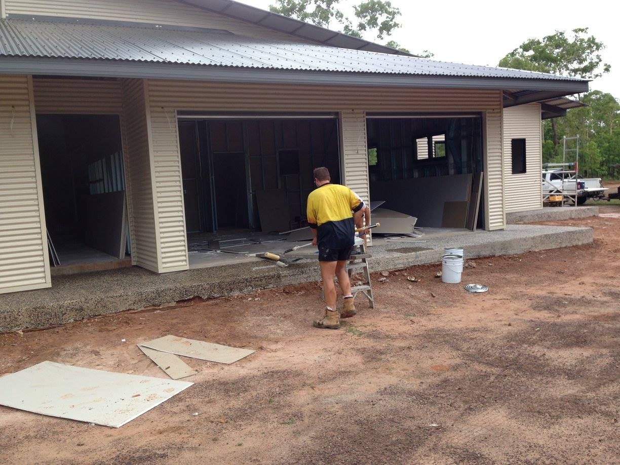 Builder working on residential construction site preparing materials and exterior structure build