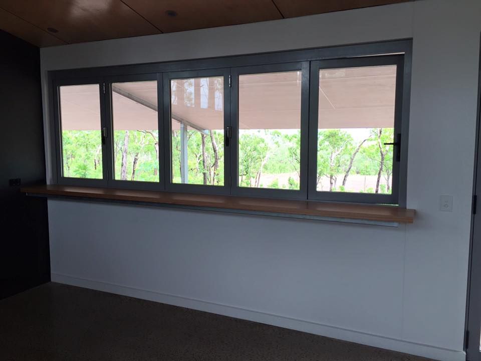 An Empty Room With A Large Window And A Wooden Counter — SLS Builders Pty Ltd in Humpty Doo, NT