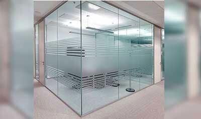 Oficina con paredes de cristal y franjas horizontales esmeriladas para mayor privacidad.
