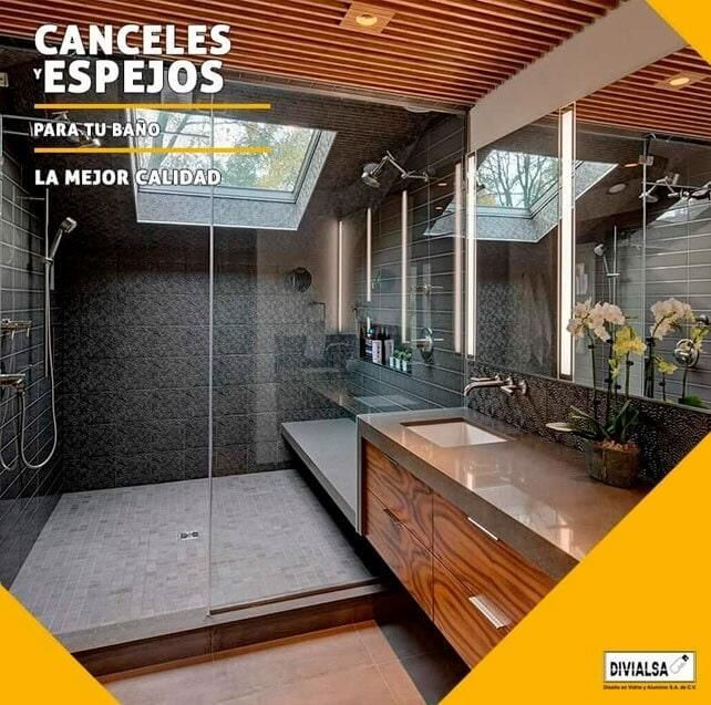 Baño moderno con ducha, lavabo y tragaluz. Detalles en madera y azulejos oscuros.
