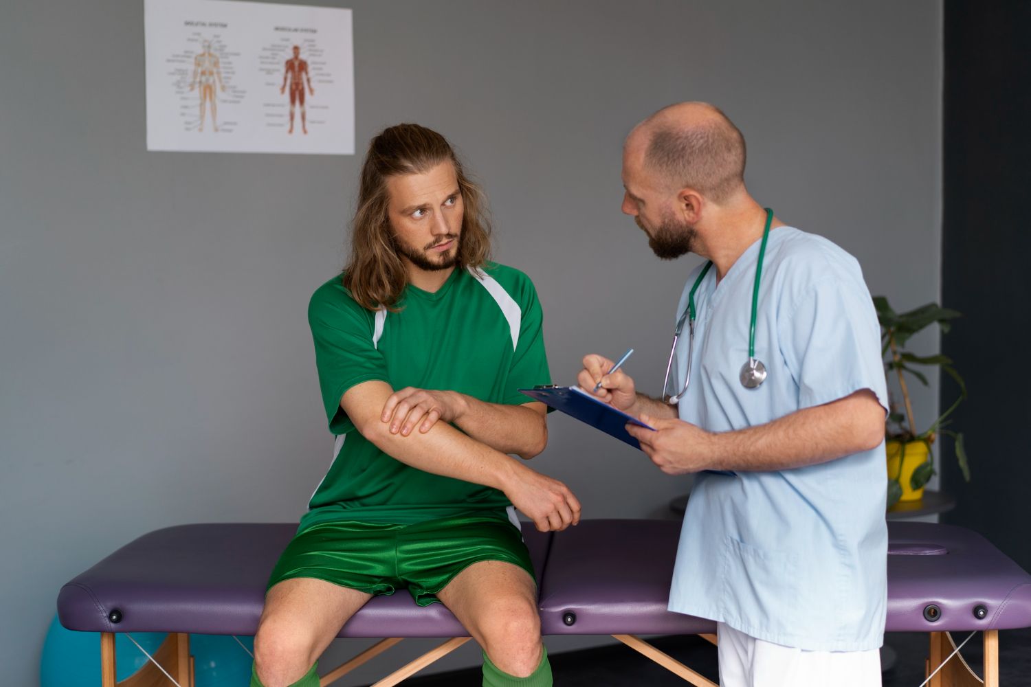 Physical therapist discussing arm exercise with patient on exam table in clinic