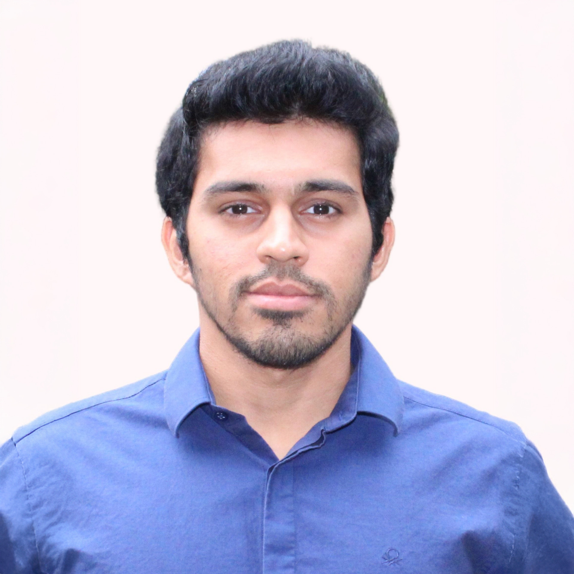 Portrait of a man in a blue shirt against a light background