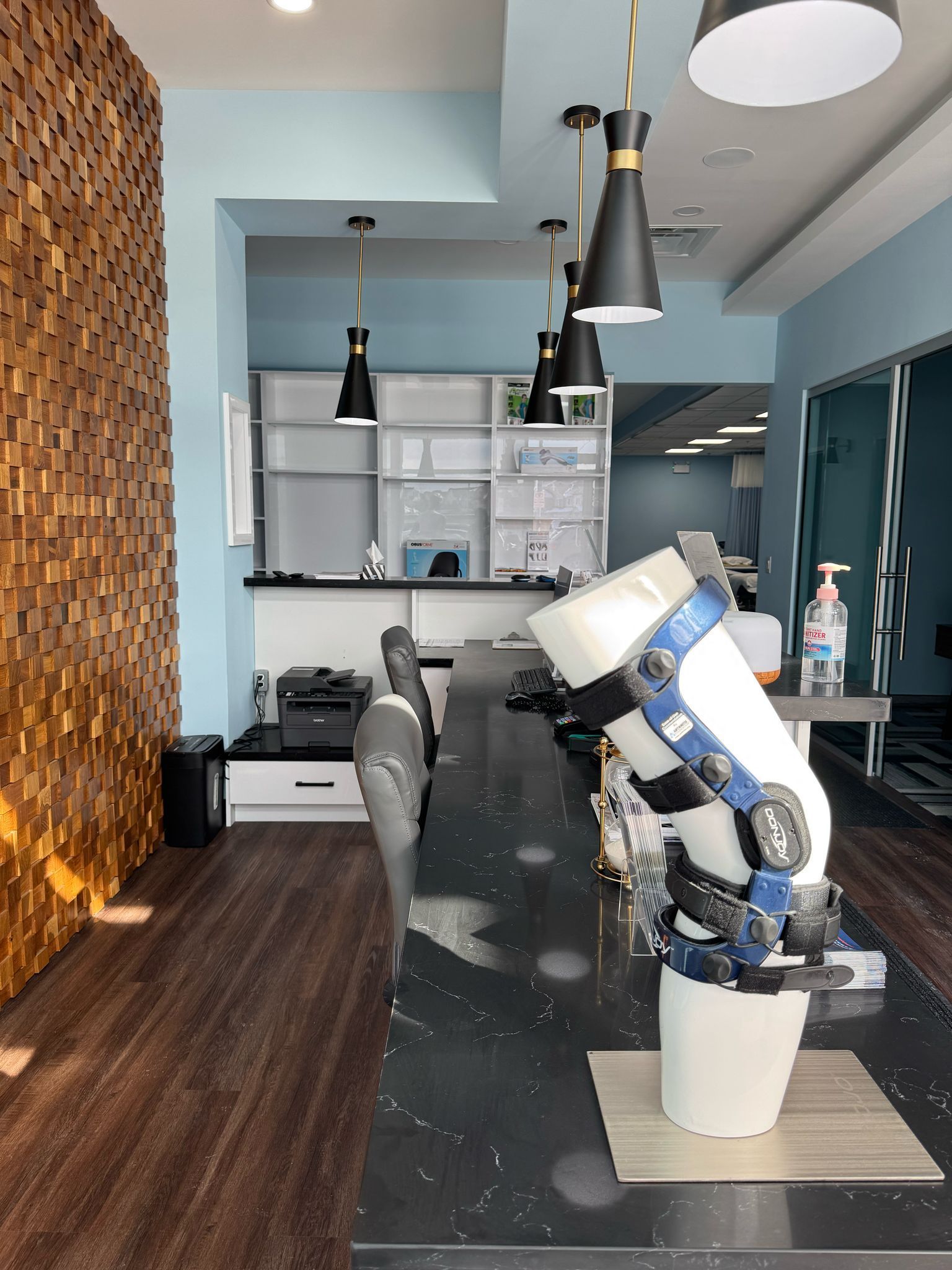 Modern salon with a white-and-blue robotic arm beside a chair and mirrors on a dark floor