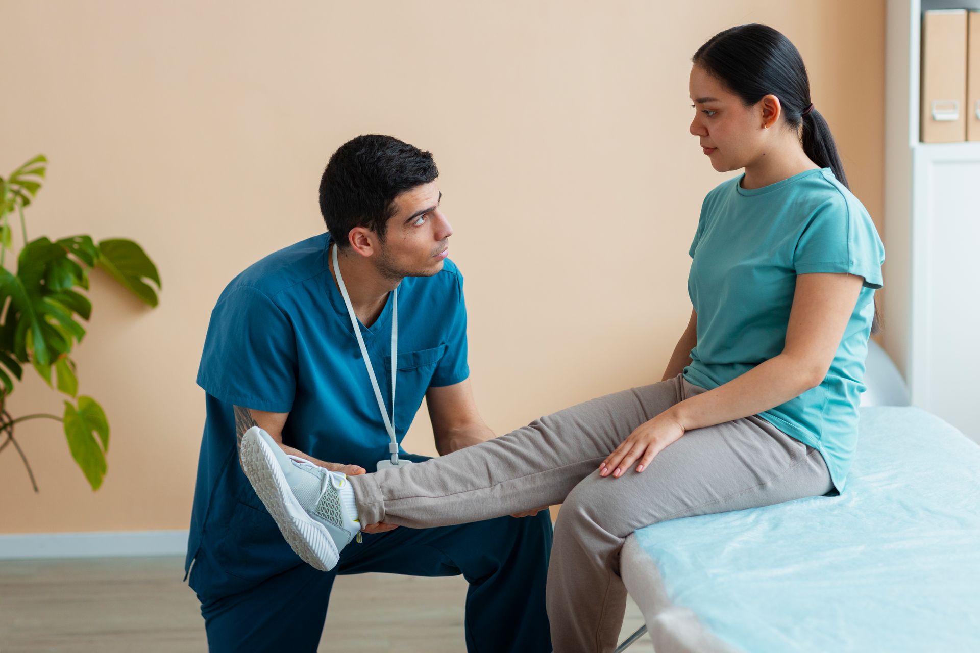 A doctor is examining a patient 's leg in a hospital room.