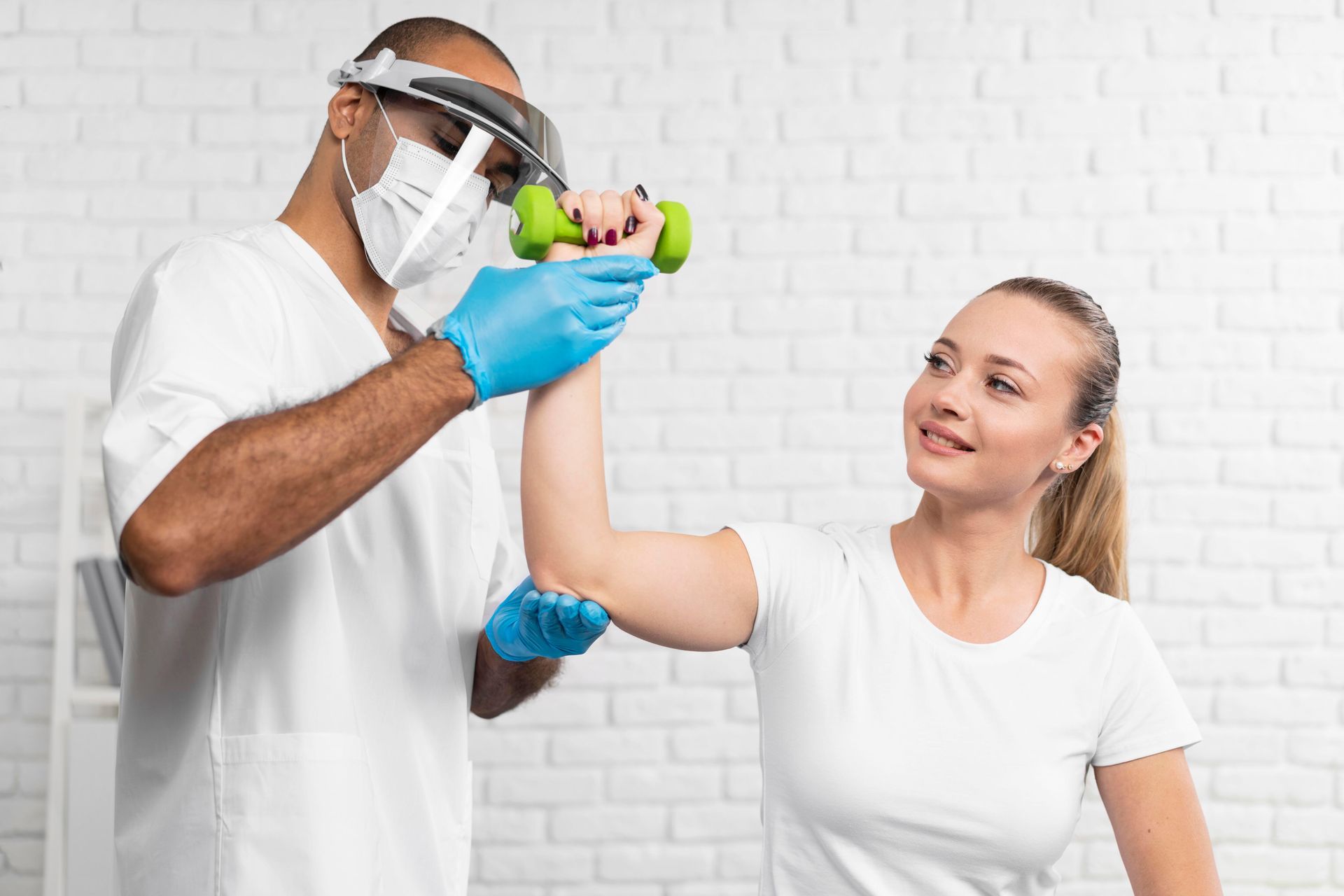 A doctor is helping a woman with a dumbbell exercise.