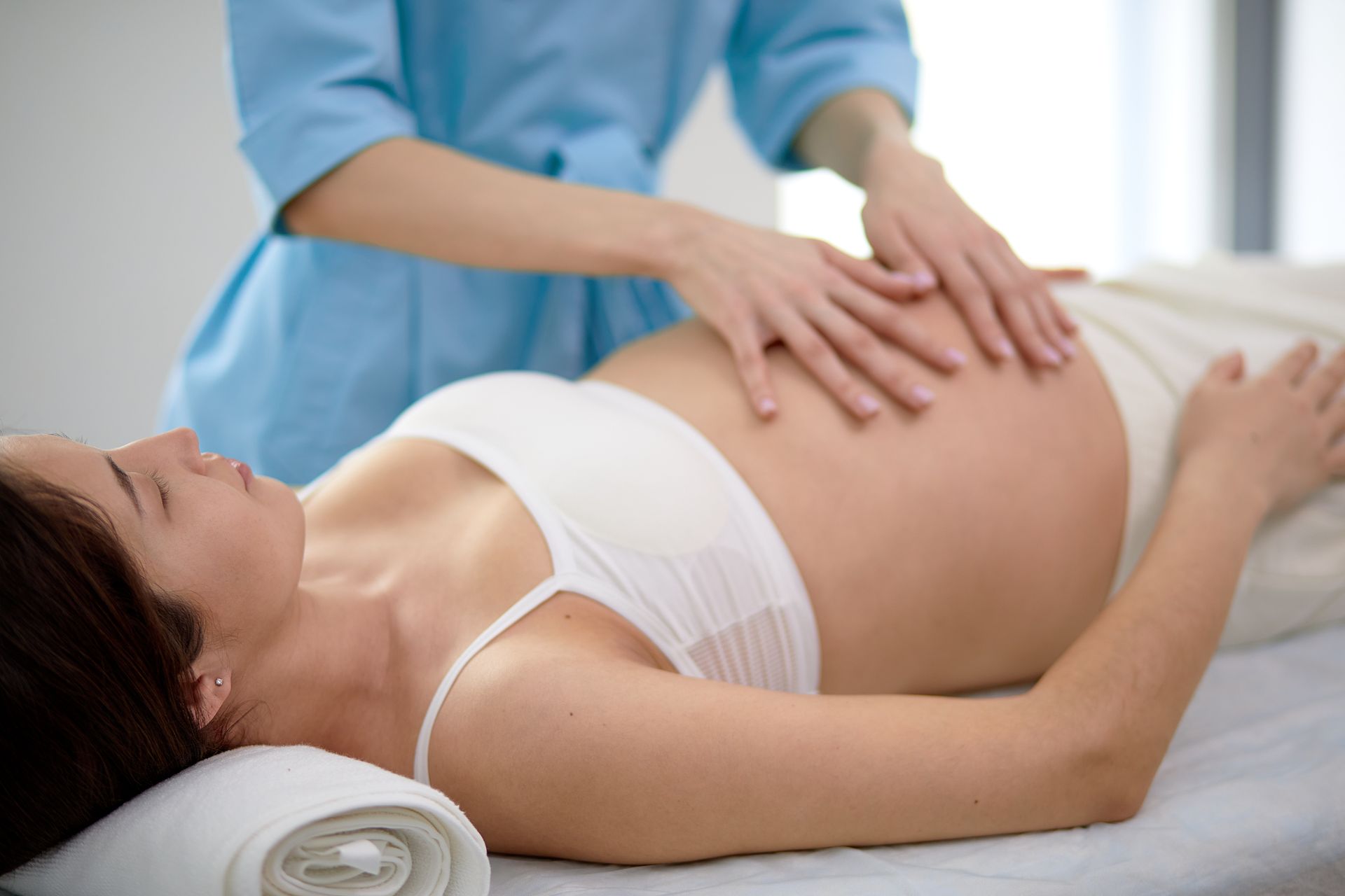 A pregnant woman is getting a massage from a man.