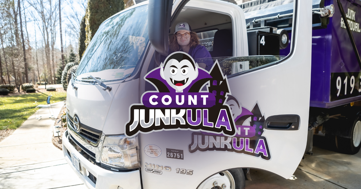 White utility truck with open side door and “COUNT JUNKULA” logo on the front and side.