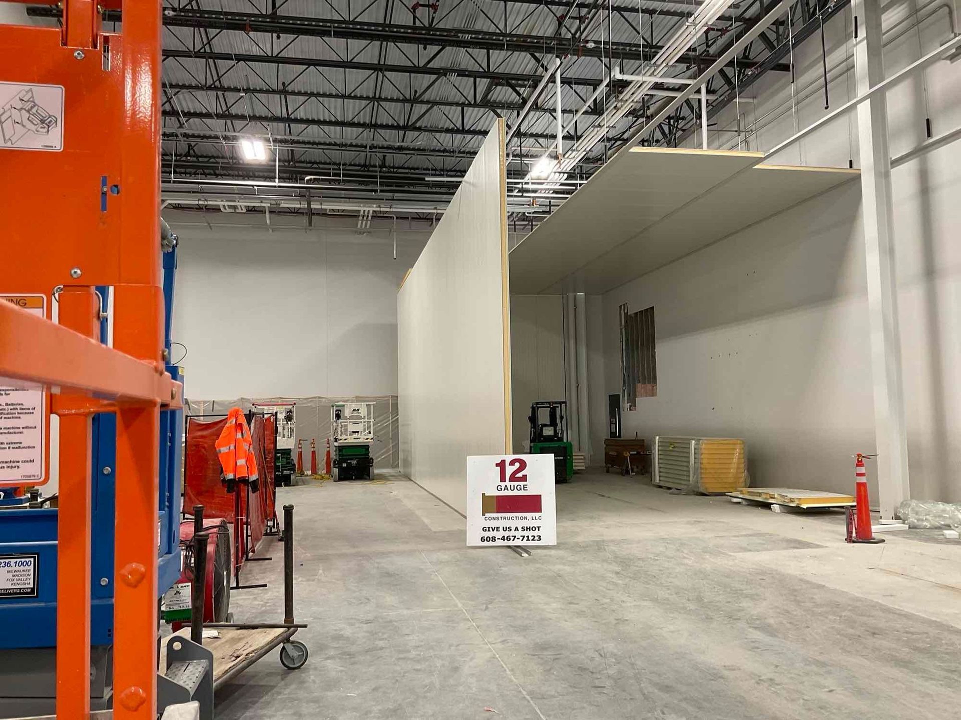 Construction site: interior view with unfinished walls, equipment, and a sign.