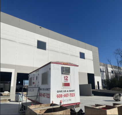 Construction site with white and gray building. A trailer with 