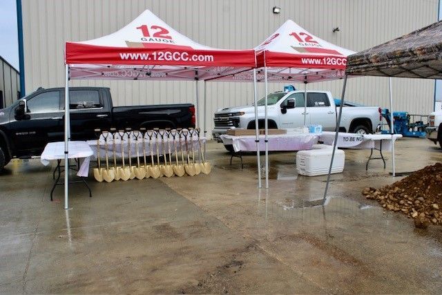 Groundbreaking event: Tents, trucks, shovels, and tables set up for a ceremony, 120CC logo visible.