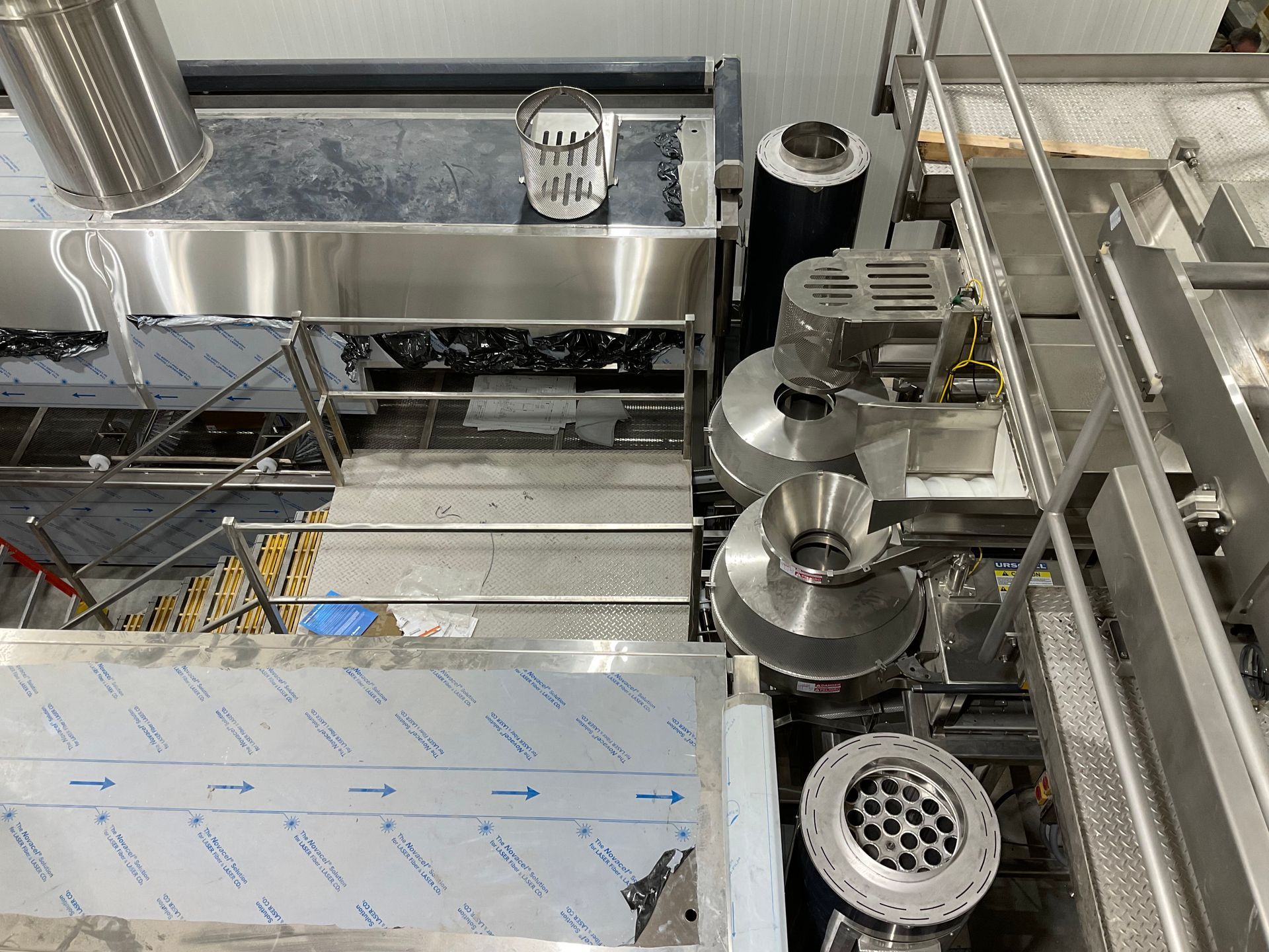 Overhead view of stainless steel industrial machinery in a factory setting.