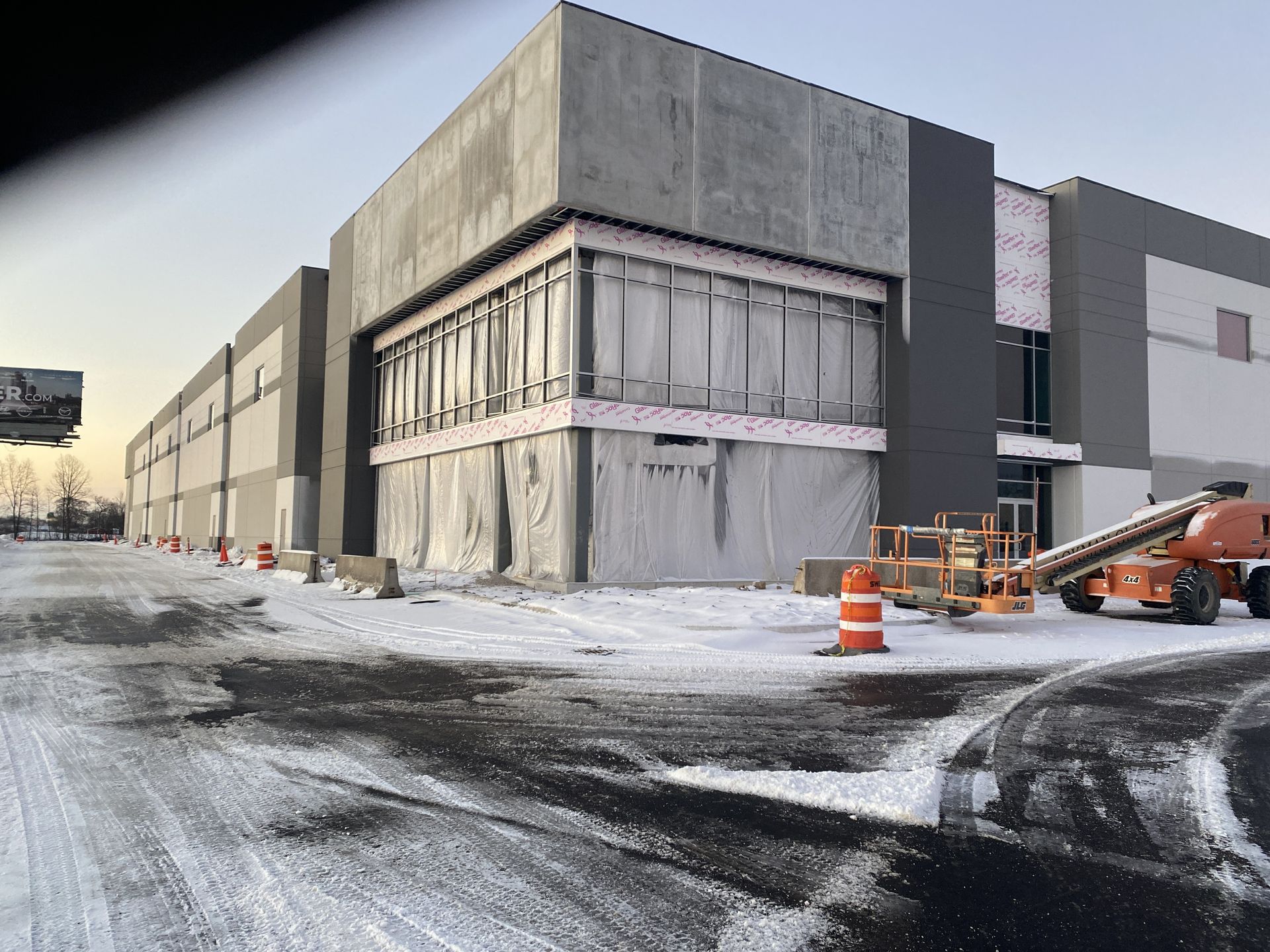 Industrial building under construction, exterior view with snow on the ground.