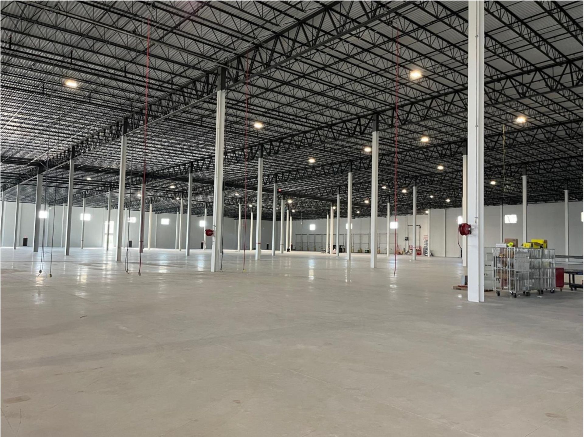 Empty industrial warehouse interior with high metal ceiling and white support columns