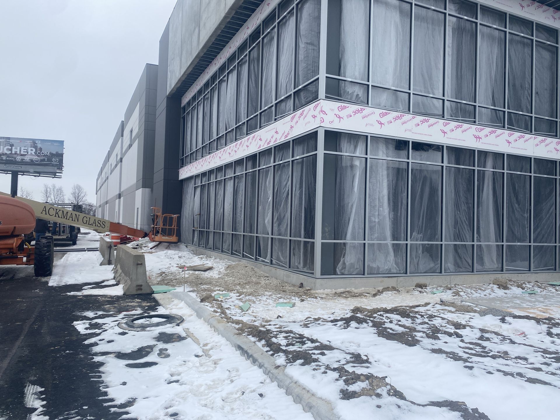 Building under construction with covered windows in a snowy environment.