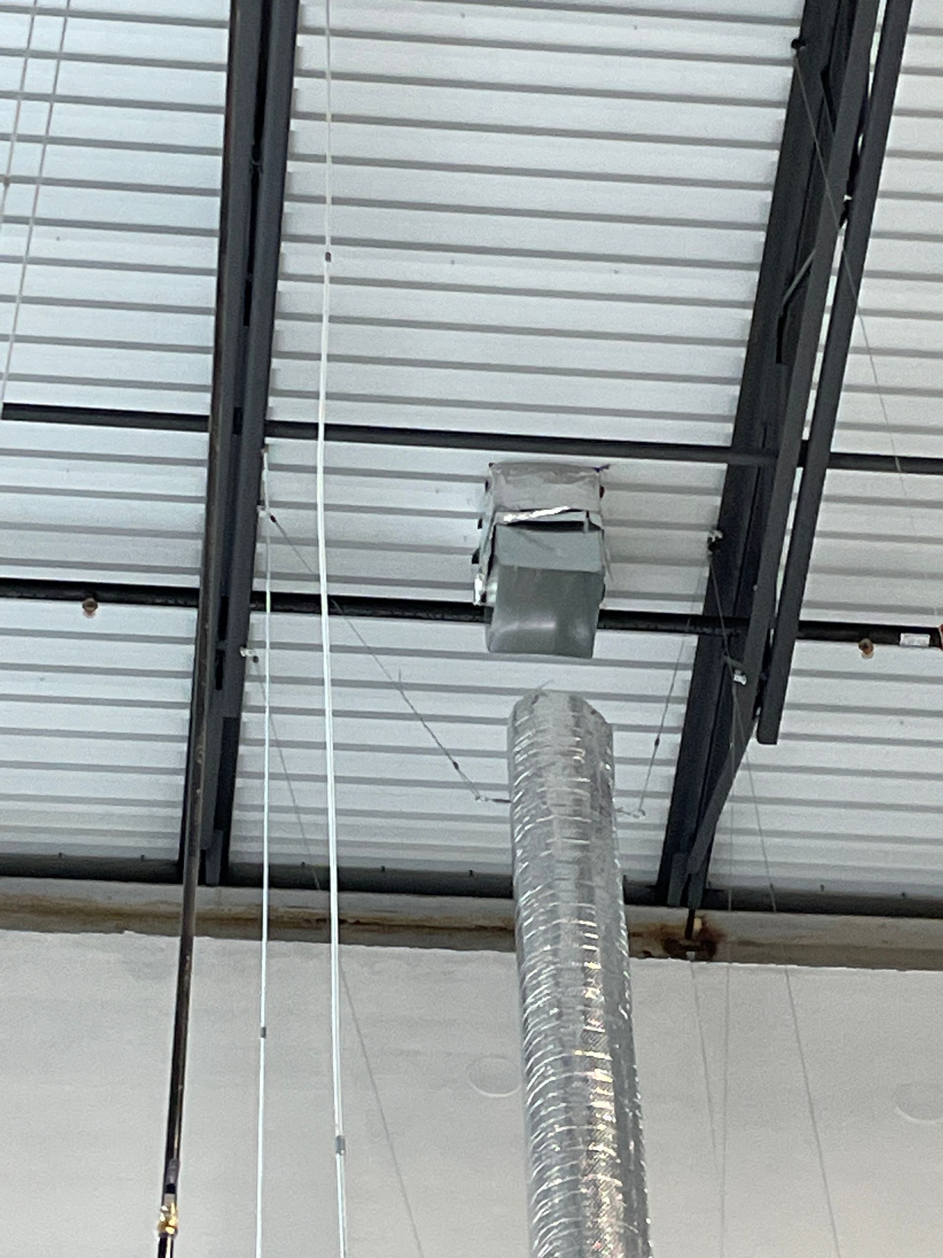 Ceiling with exposed ductwork and hanging cables in an industrial interior