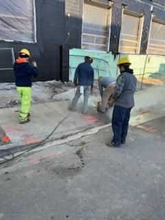 Construction workers in hard hats working on concrete.