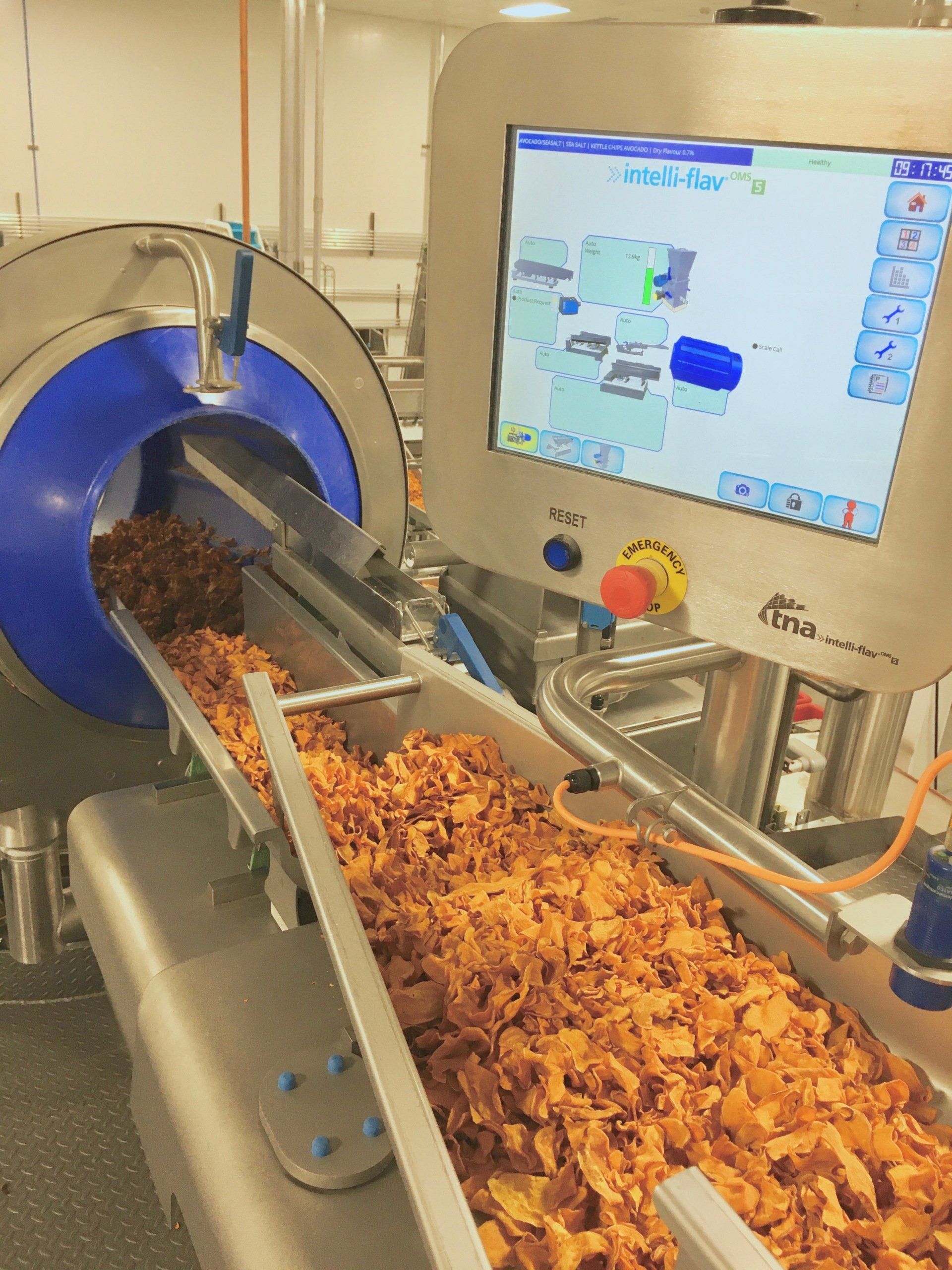 Machine filling and dispensing food product onto conveyor belt. Touchscreen control panel.