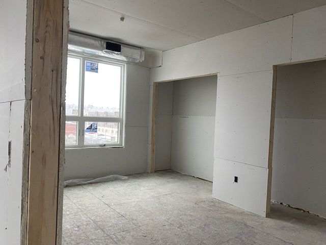Interior room under construction with drywall and window.