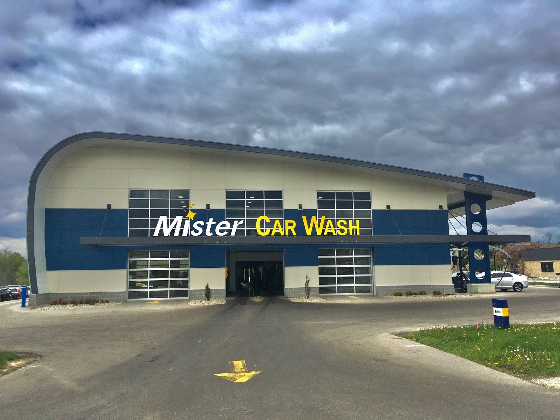 Mister Car Wash exterior with blue and white facade under a cloudy sky.