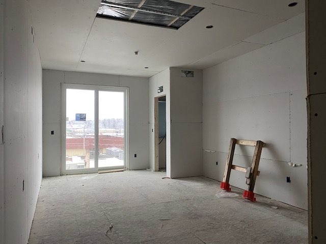 Interior room under construction with drywall walls and a sliding glass door.