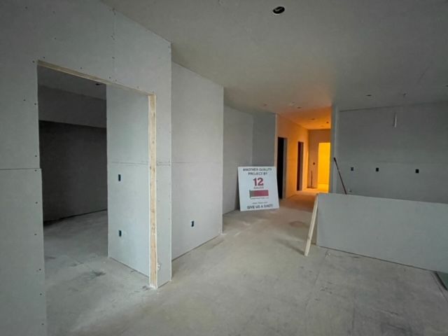 Interior of a building under construction, with drywall installed on walls.