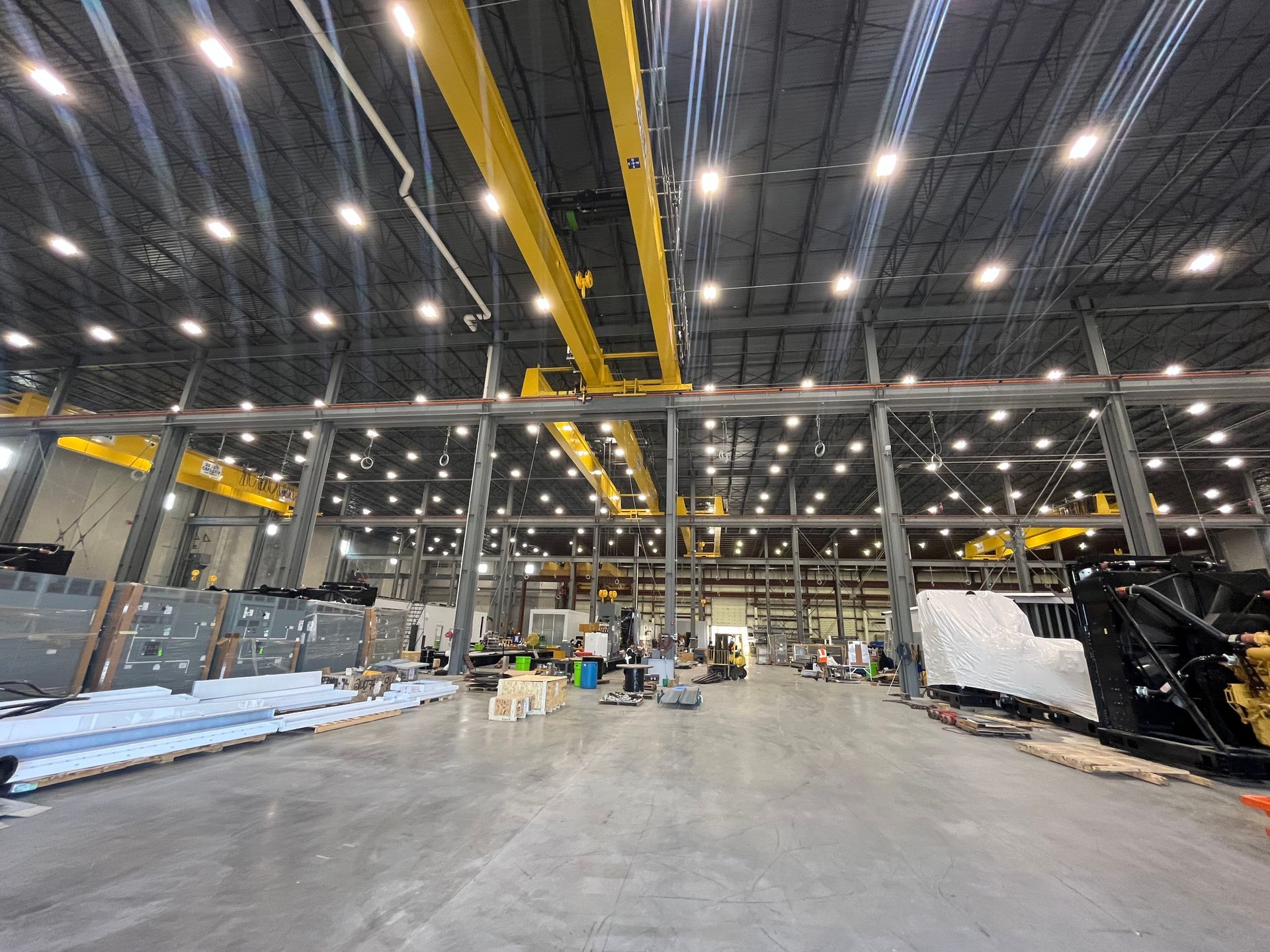 Large industrial workshop with overhead cranes and workers.