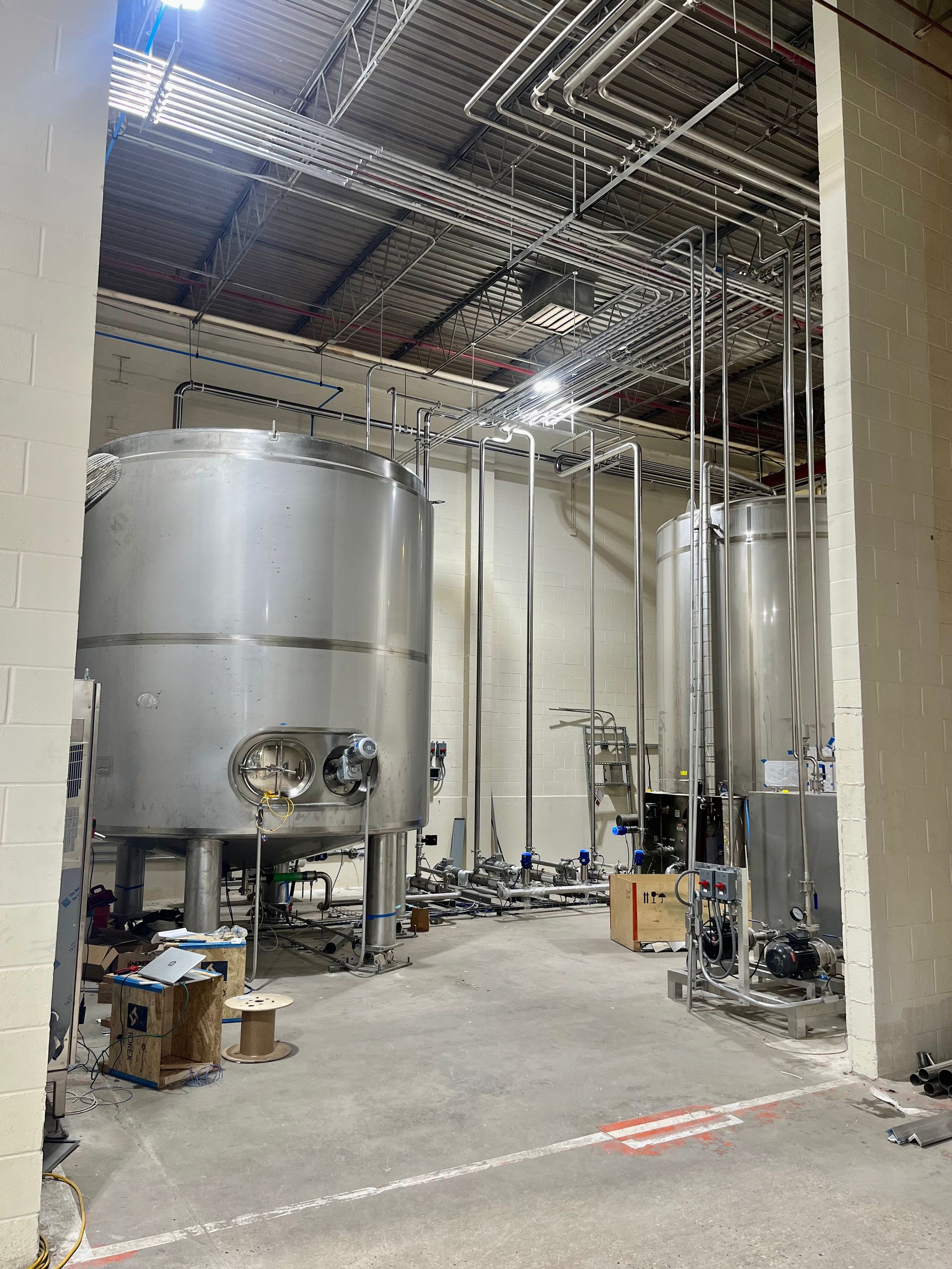 Stainless steel tanks and piping in a factory setting.