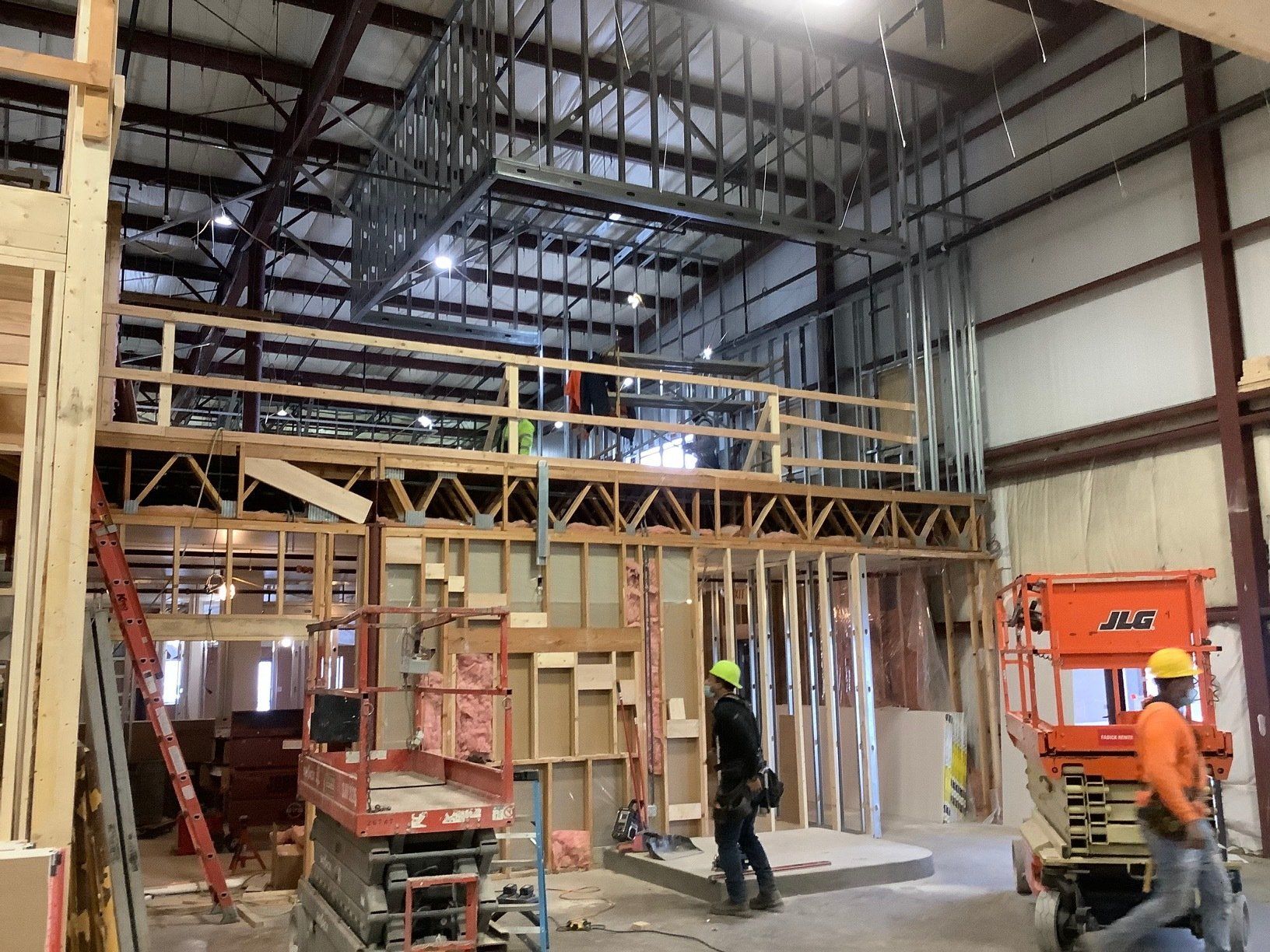 Construction site: Interior view of a building with a mezzanine and workers.
