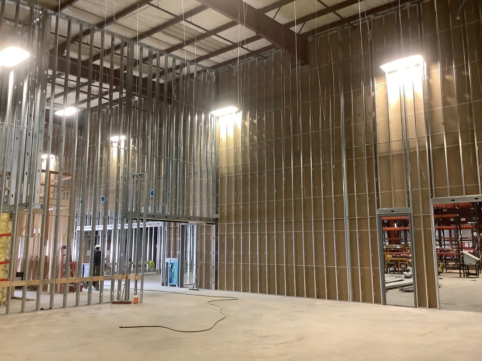 Interior view of a warehouse construction. Metal framing and insulation are visible.
