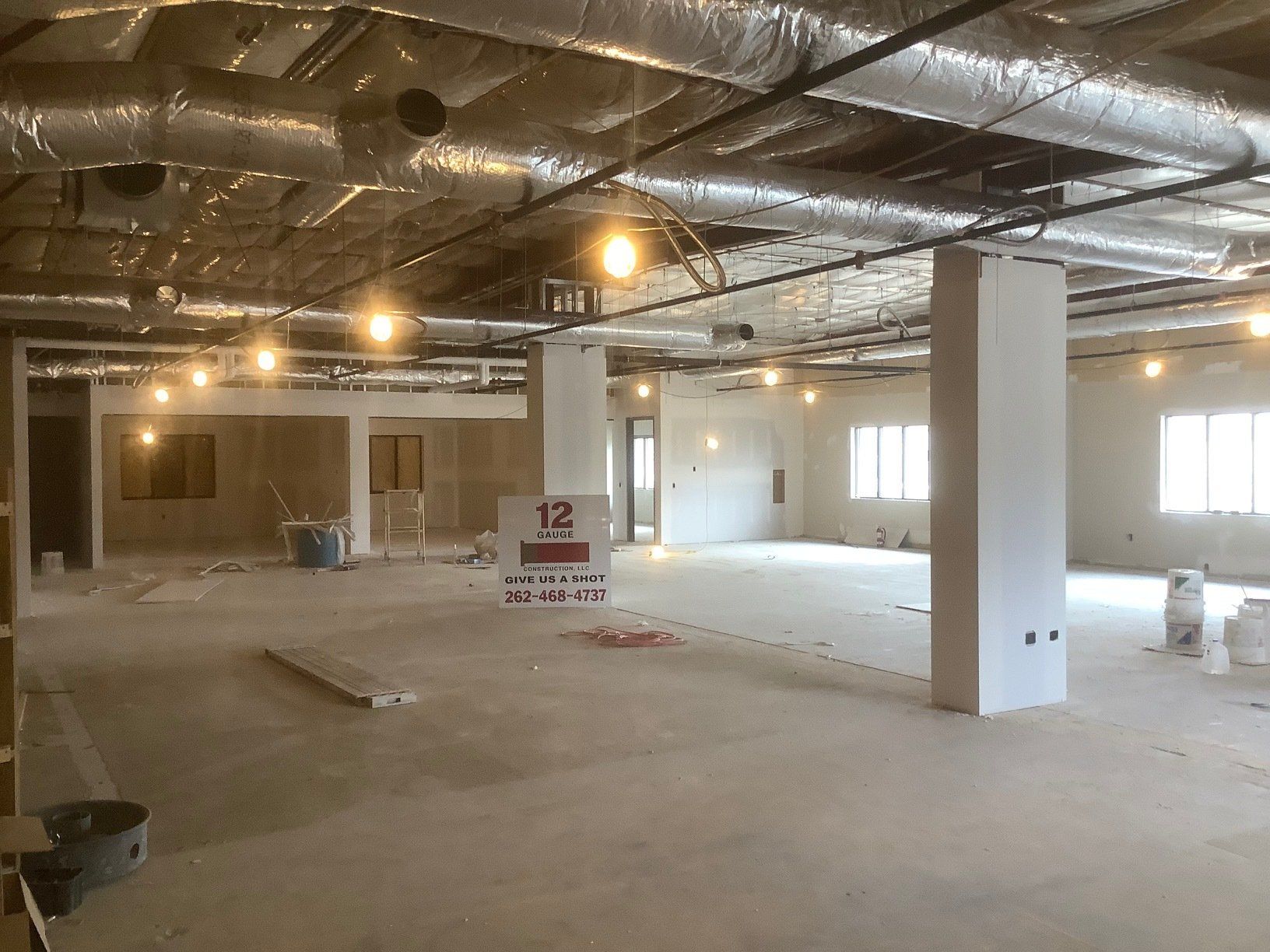Interior of a construction site with exposed ceiling, concrete floor, and unfinished walls.