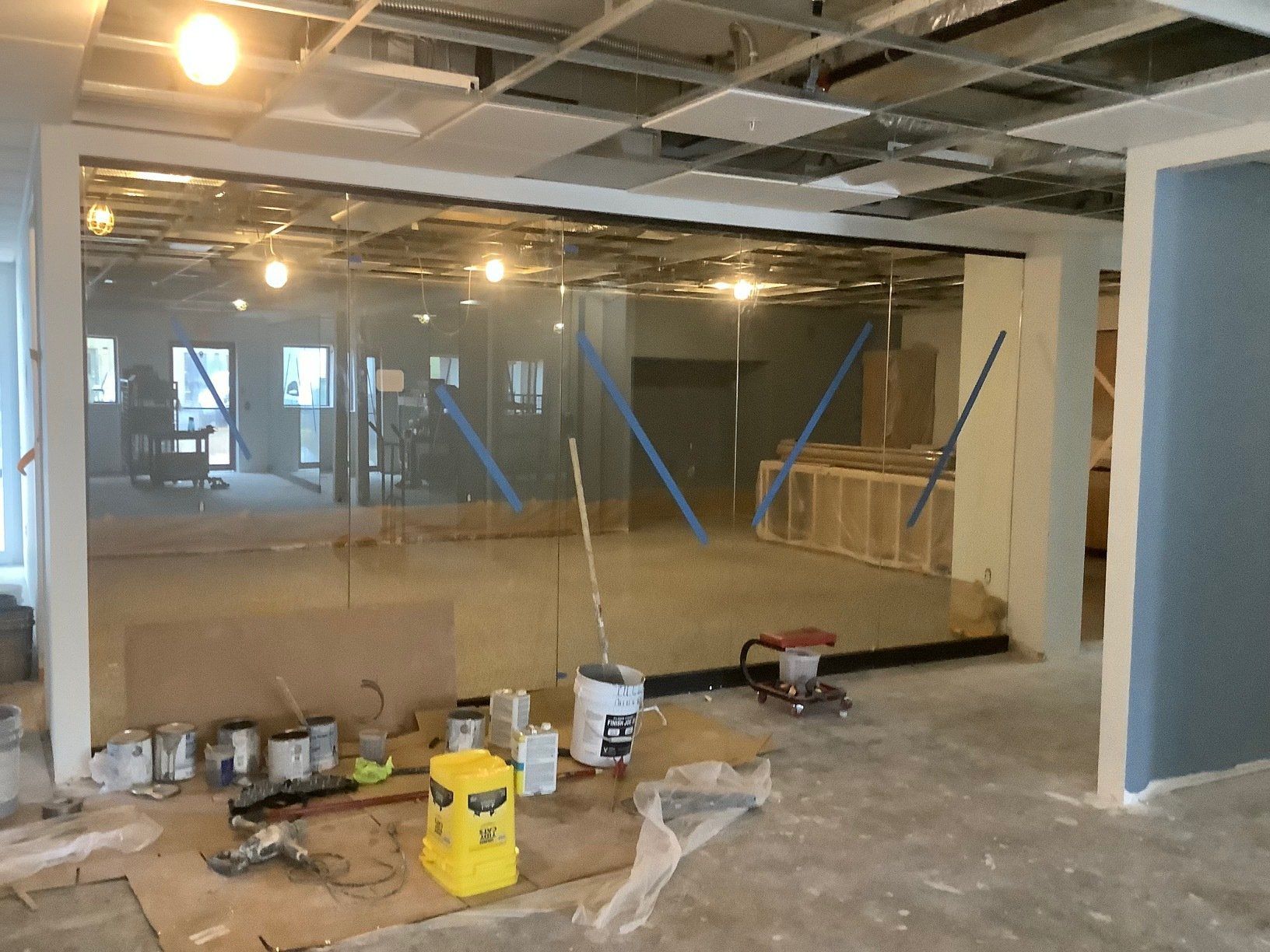 Interior of a room under construction, with exposed ceiling, tools, and a partially built wall.