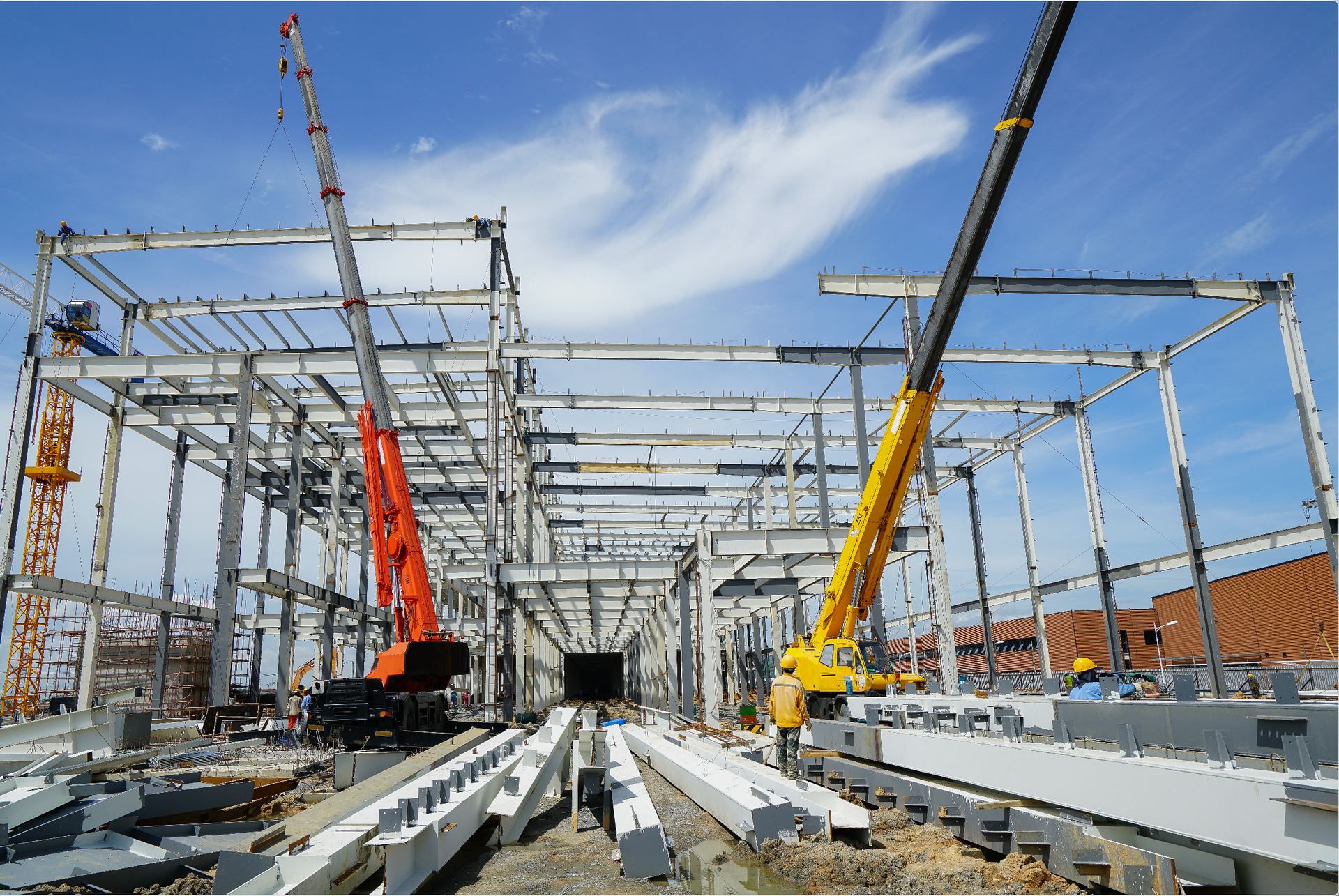 Construction site with cranes erecting steel framework for a building.