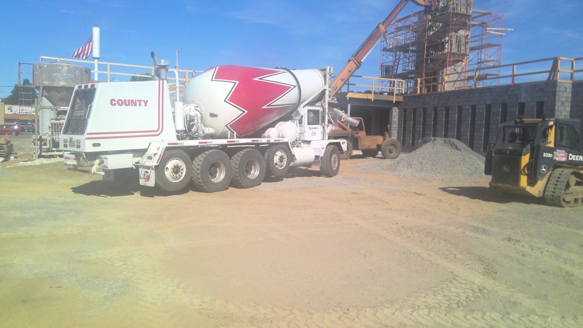 Concrete mixer truck at a construction site, pouring concrete.