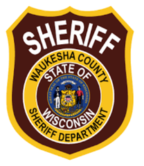Waukesha County Sheriff's Department badge, brown and gold shield with text and Wisconsin state seal.