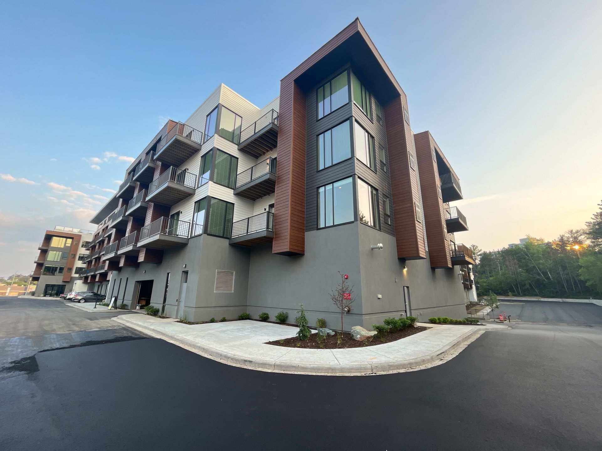 Modern apartment building exterior with angular design, balconies, and wood accents.