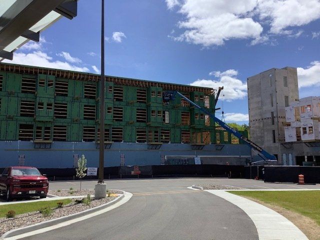 Building construction site. Large wooden frame of a building with blue lift. Cloudy sky.